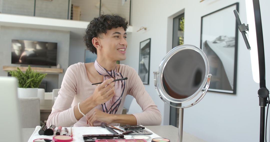 Young Man Applying Makeup at Home with Mirror and Light