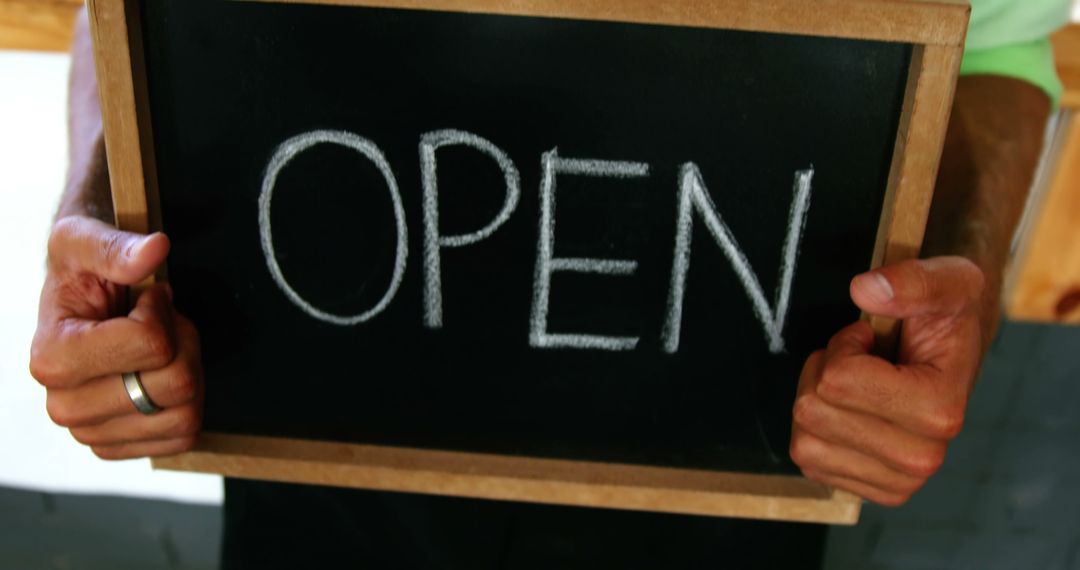 Hands of caucasian male business owner holding chalkboard open sign - Free Images, Stock Photos and Pictures on Pikwizard.com