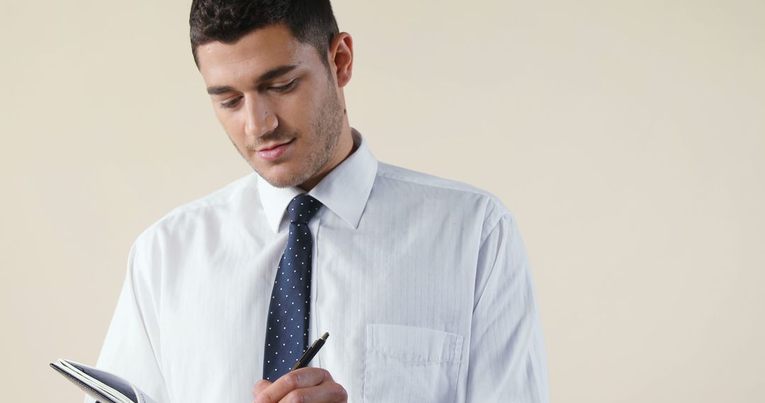 Focused Businessman Writing Notes for Meeting Preparation