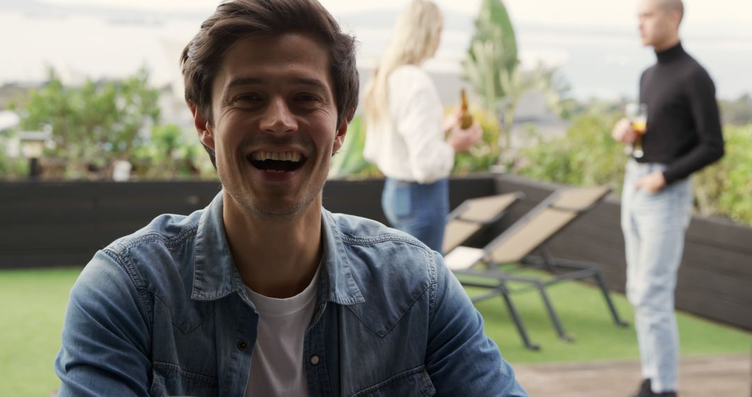 Cheerful Man Enjoying Rooftop Gathering - Free Images, Stock Photos and Pictures on Pikwizard.com