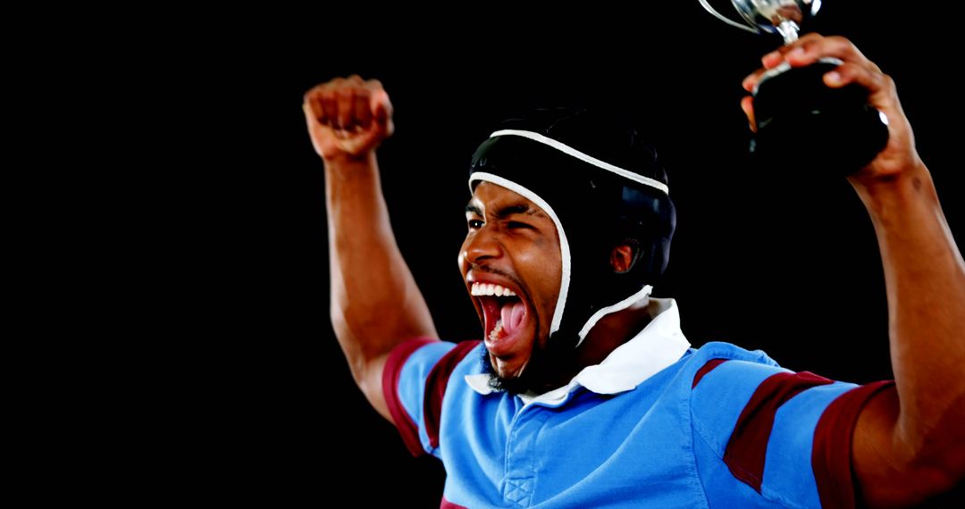 African American rugby player celebrating victory holding trophy - Free Images, Stock Photos and Pictures on Pikwizard.com