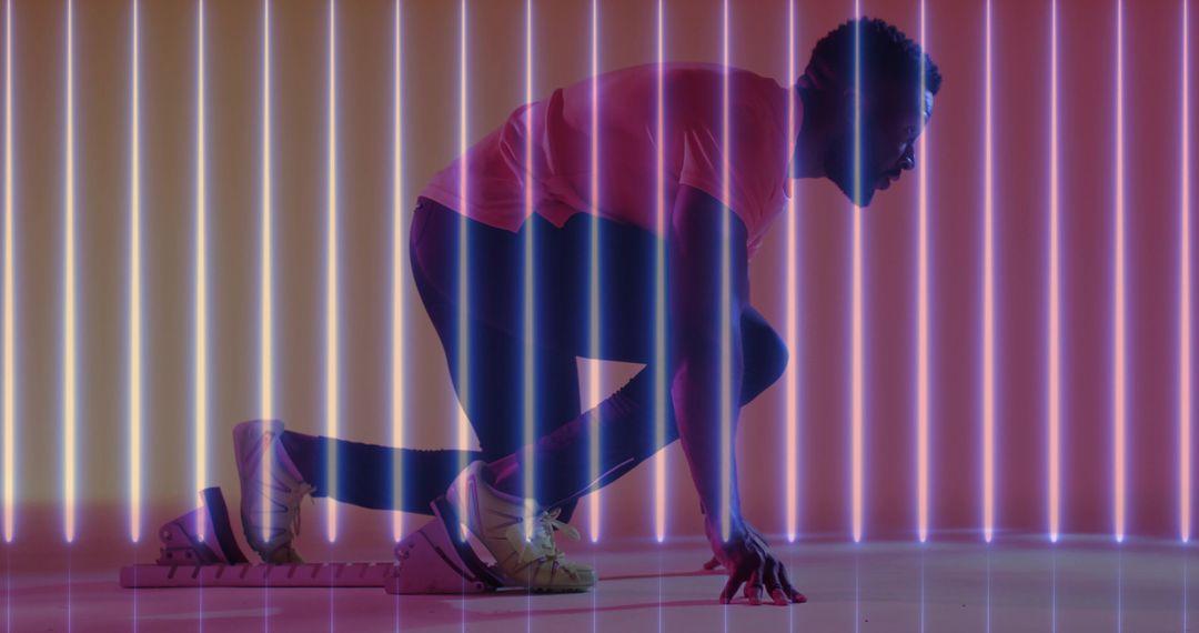 Sprinter crouching on starting blocks with neon backlight, urban fitness and speed concept
