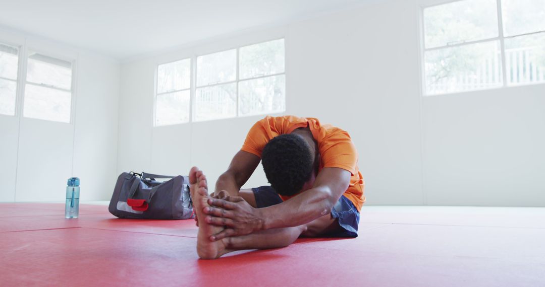 Man Stretching on Red Mat in Gym Room - Free Images, Stock Photos and Pictures on Pikwizard.com