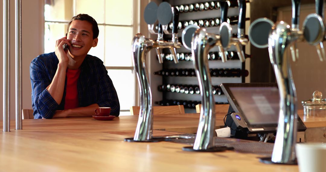 Asian Man Chatting Relaxed at Bar Countertop with Copy Space
