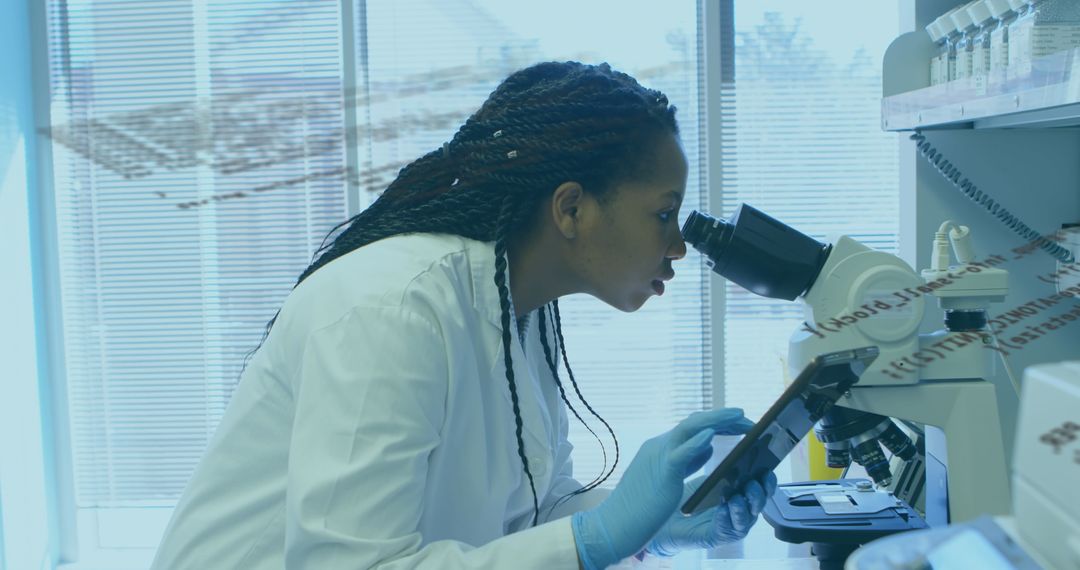 Female Scientist Analyzing Microscope Data on Tablet