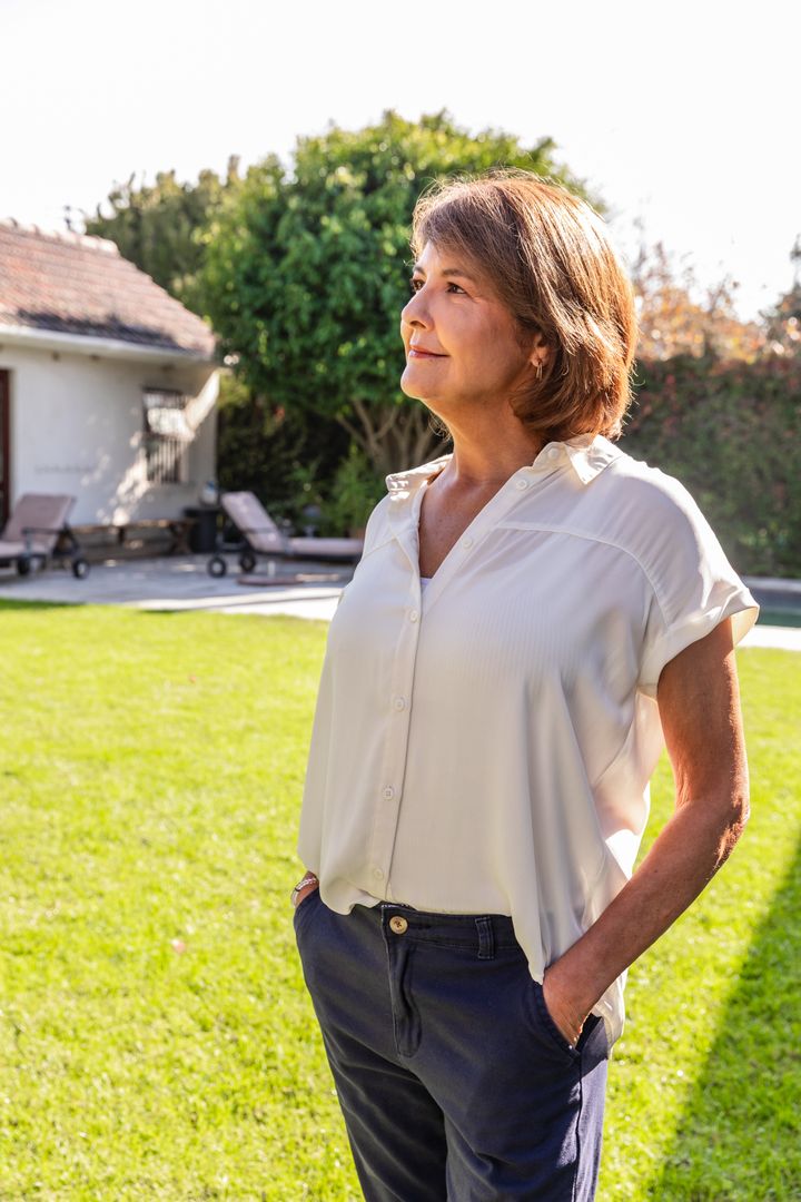 Woman Contemplatively Gazing at Sky in Sunlit Backyard