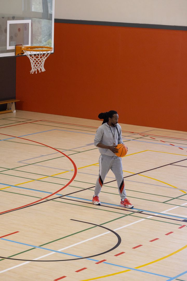Basketball Coach Preparing in Gymnasium with Ball and Whistle