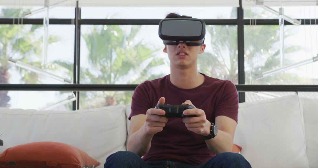 Young Man Wearing VR Headset and Gaming on Couch - Free Images, Stock Photos and Pictures on Pikwizard.com
