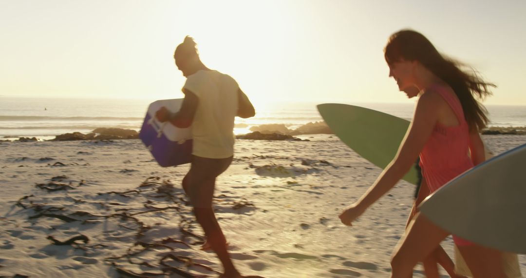 Friends Walking on Beach at Sunset with Surfboards - Free Images, Stock Photos and Pictures on Pikwizard.com