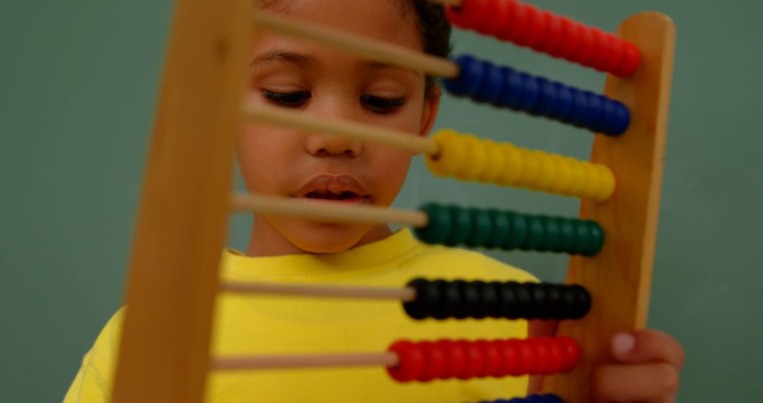 Child Learning Math with Abacus in Classroom Focused on Education