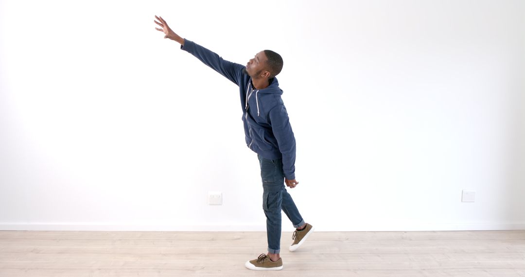 Man in Casual Outfit Indoors with Reaching Gesture
