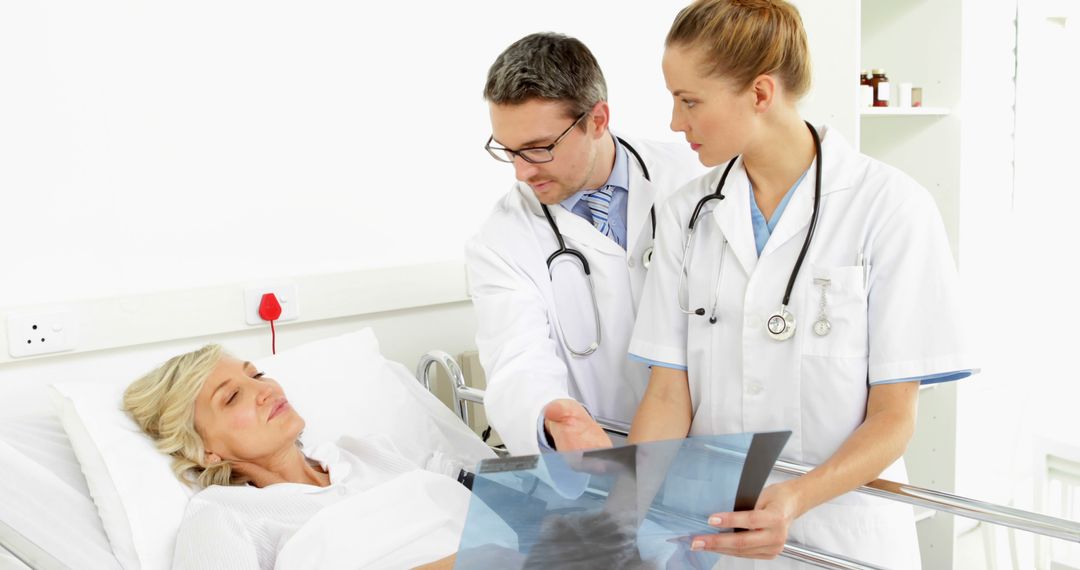 Doctors Discussing X-Ray Results with Female Patient in Hospital Bed - Free Images, Stock Photos and Pictures on Pikwizard.com