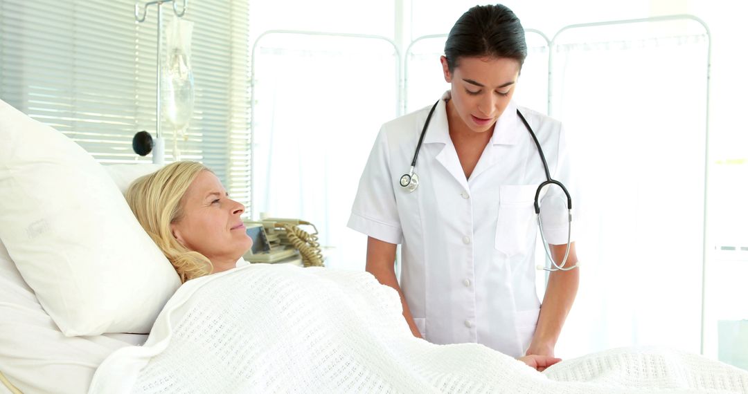 Female Nurse Checking on Blonde Patient in Hospital Bed - Free Images, Stock Photos and Pictures on Pikwizard.com