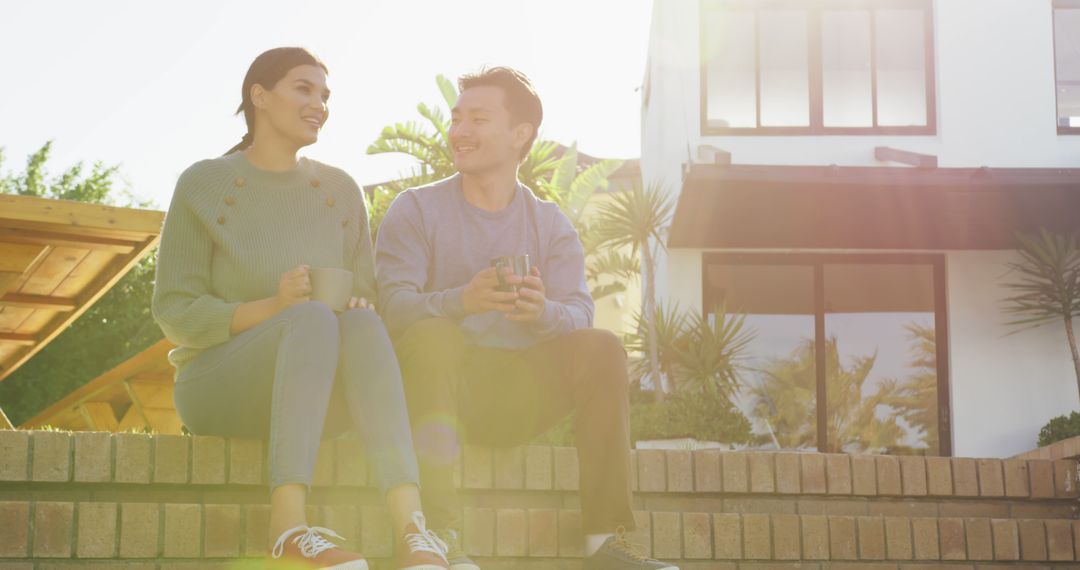 Image of happy diverse couple talking and drinking coffee in garden - Free Images, Stock Photos and Pictures on Pikwizard.com