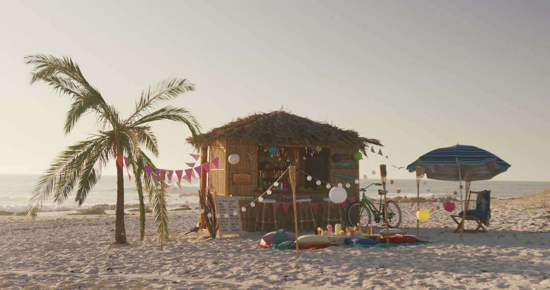 Tropical Beach Hut During Sunset with Bike, Umbrella, and Palm Tree - Free Images, Stock Photos and Pictures on Pikwizard.com