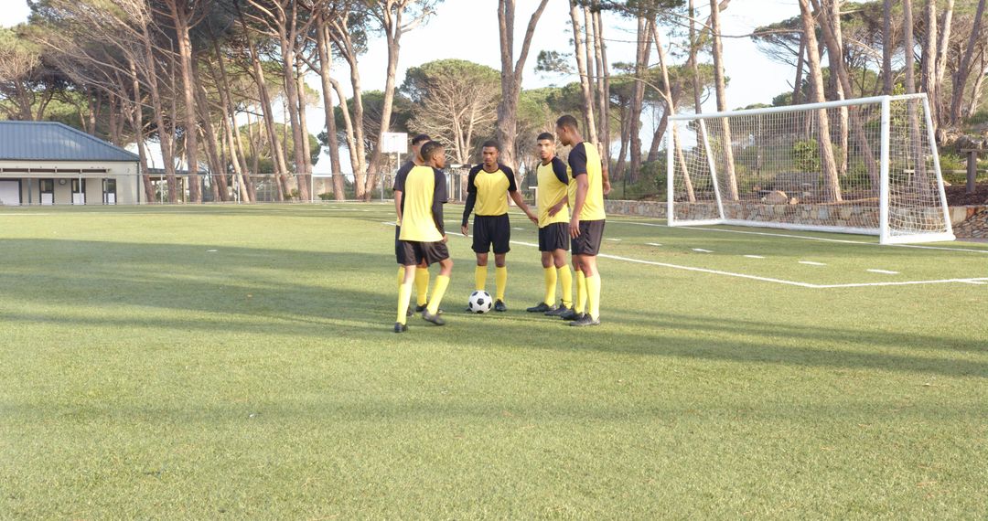 Soccer Team Strategizing on Field Before Practice Session