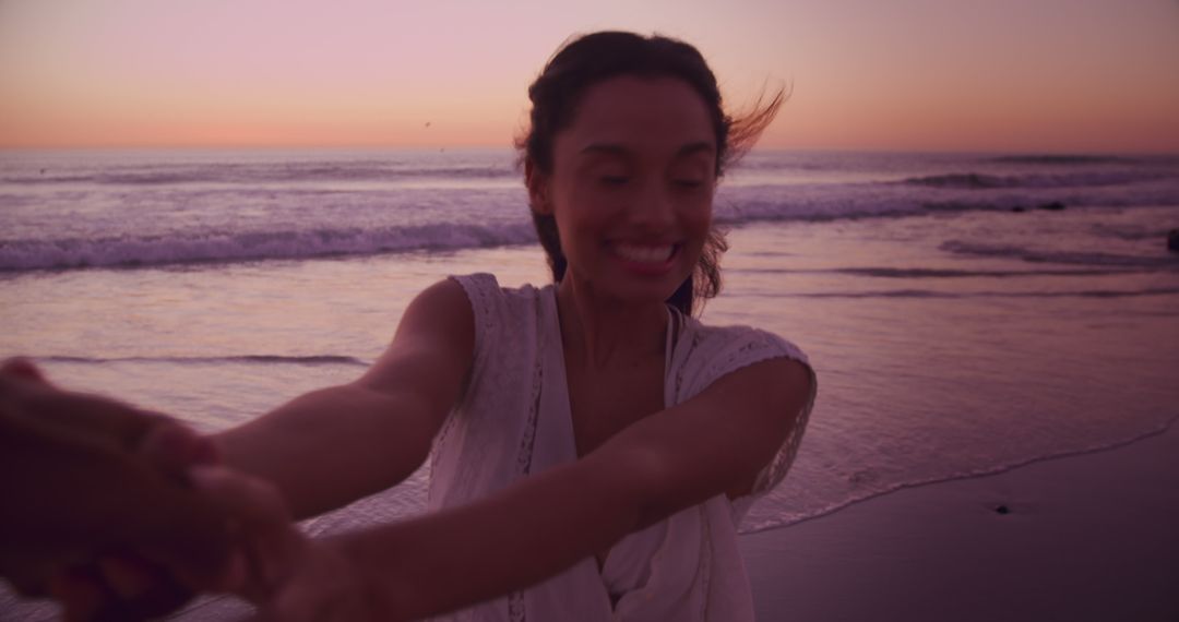 Woman Enjoying Sunset at Beach Holding Hands and Smiling - Free Images, Stock Photos and Pictures on Pikwizard.com