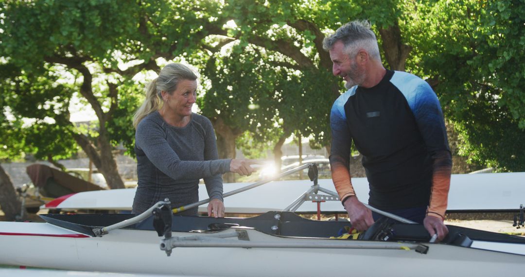 Mature Athletes Preparing Rowing Boat for Training Session Outdoors - Free Images, Stock Photos and Pictures on Pikwizard.com