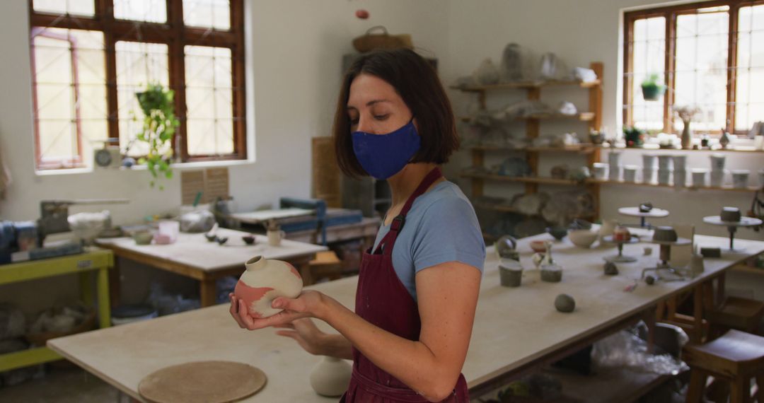 Focused Female Potter in Mask Shaping Clay Vase - Free Images, Stock Photos and Pictures on Pikwizard.com