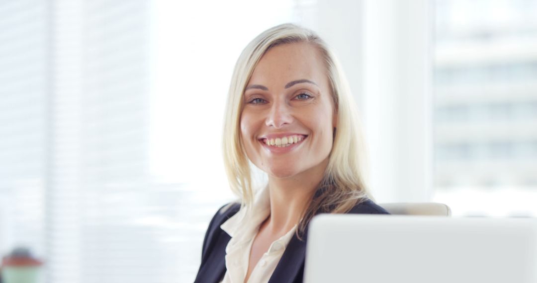 Confident Businesswoman Smiling at Office Desk - Free Images, Stock Photos and Pictures on Pikwizard.com