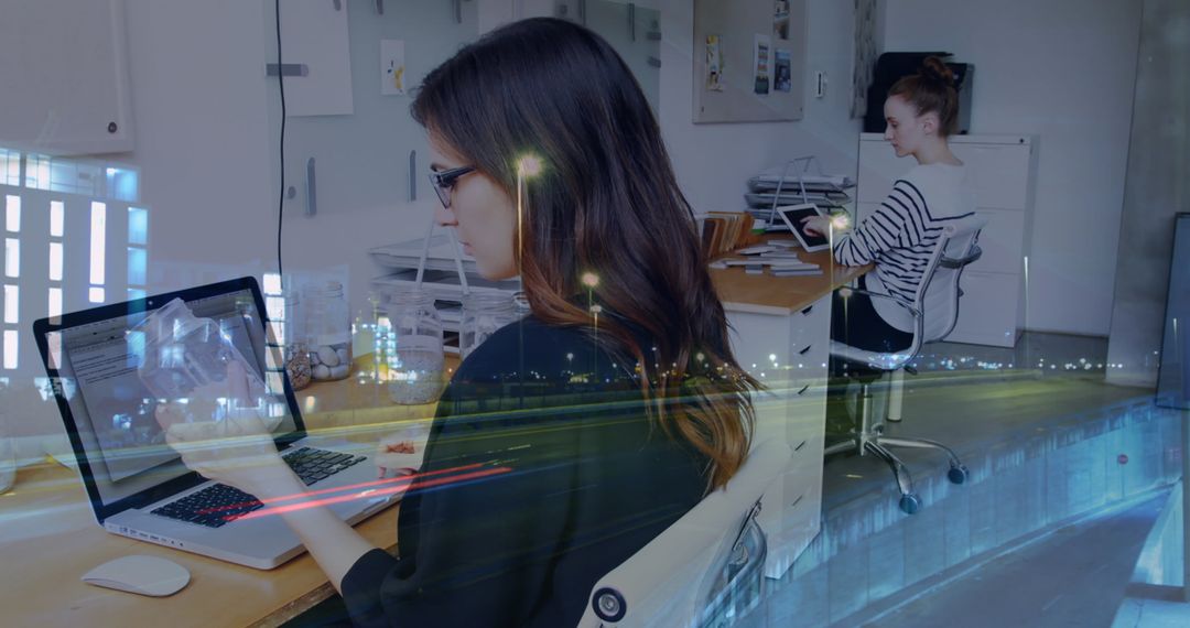 Female Colleagues Using Laptops in Modern Office with Cityscape Overlay