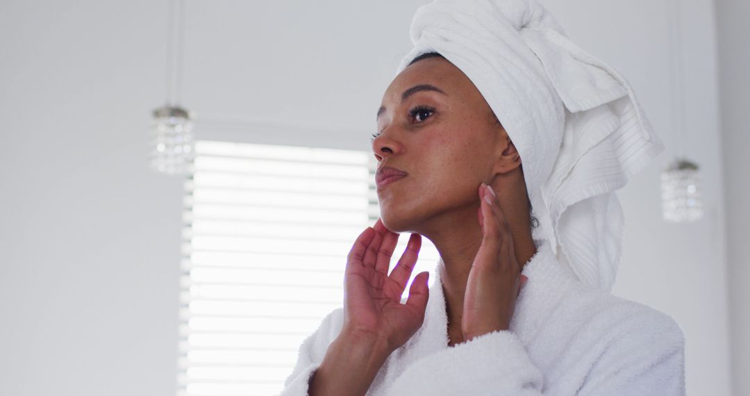 Woman with Towel on Head Applying Skincare Product in Bathroom - Free Images, Stock Photos and Pictures on Pikwizard.com