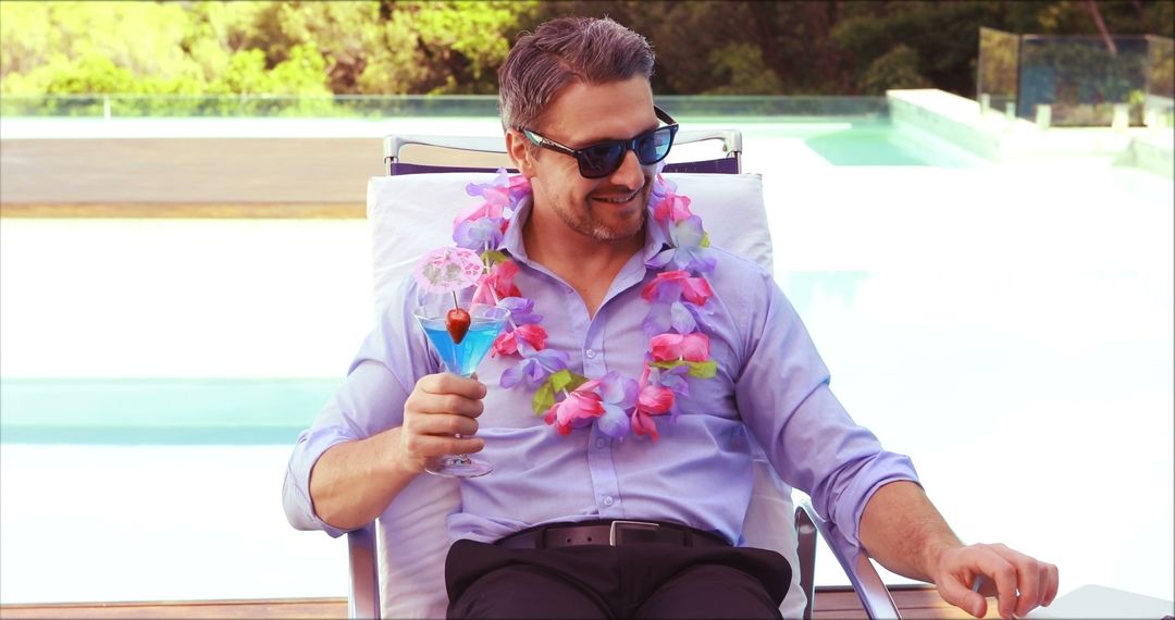 Man Relaxing by Poolside with Tropical Drink and Floral Lei - Free Images, Stock Photos and Pictures on Pikwizard.com