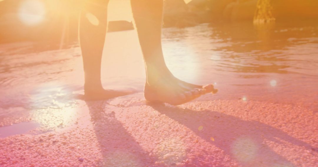 Bare Feet Splashing in Sunset Water Reflection