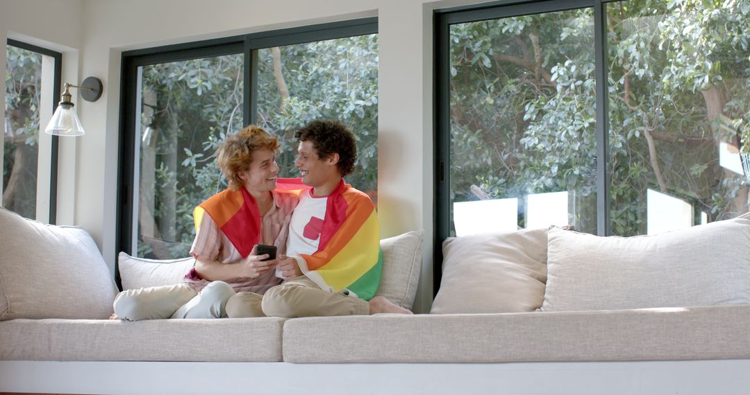 Gay Couple With Rainbow LGBT Flag Relaxing at Home