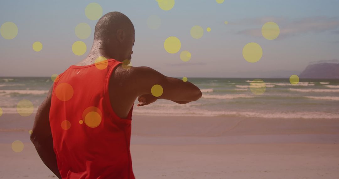 Athletic Man Checking Smartwatch on Sunlit Beach