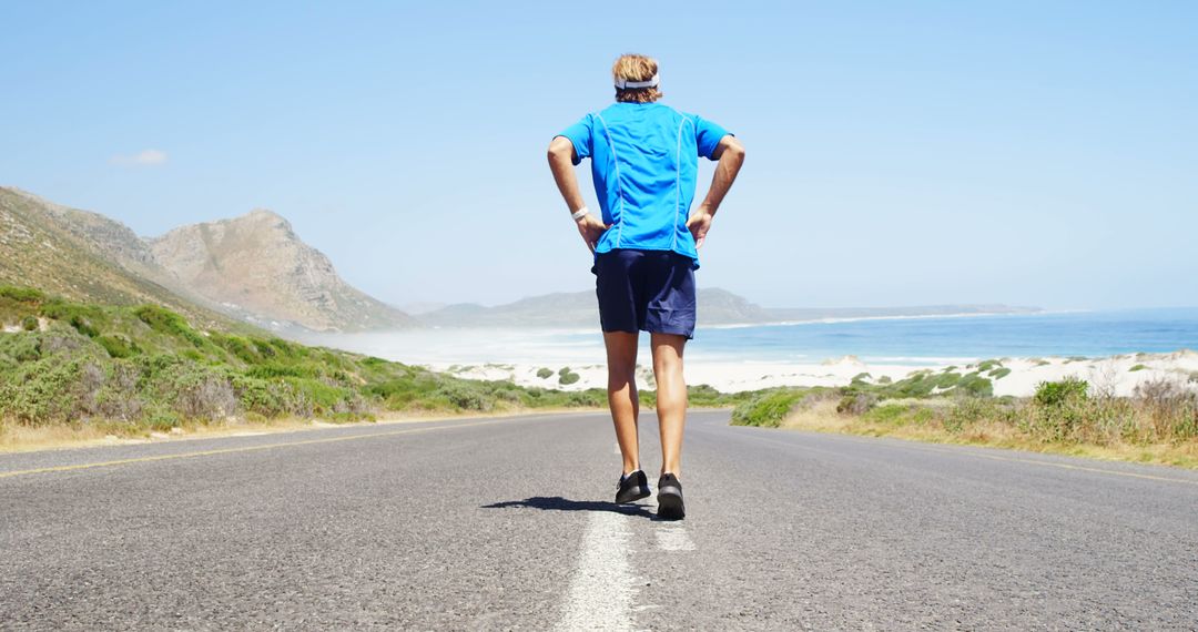 Man Running on Coastal Road with Scenic Mountain View - Free Images, Stock Photos and Pictures on Pikwizard.com