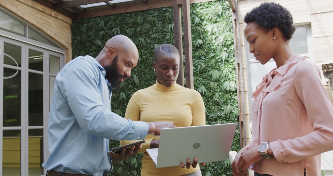 Diverse Professionals Collaborating with Technology Outdoors