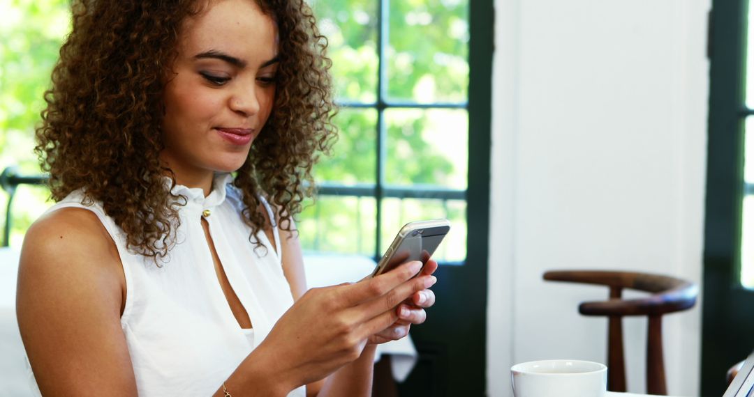 Woman Sitting at Cafe Using Smartphone - Free Images, Stock Photos and Pictures on Pikwizard.com