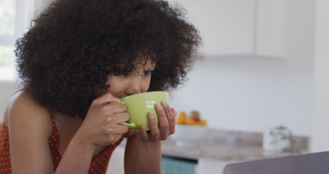 Young Girl Enjoying Hot Beverage in Modern Kitchen - Free Images, Stock Photos and Pictures on Pikwizard.com