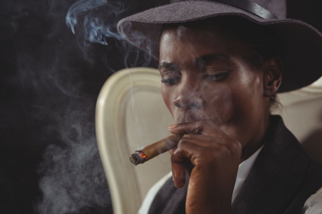 Androgynous Person Smoking Cigar in Vintage Chair - Free Images, Stock Photos and Pictures on Pikwizard.com