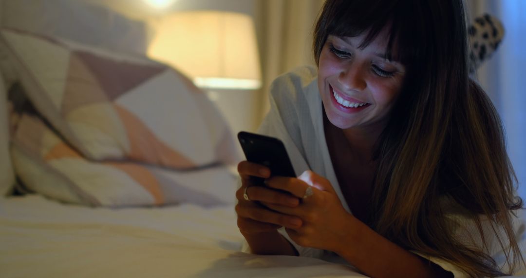 Woman Using Smartphone While Relaxing on Bed at Night - Free Images, Stock Photos and Pictures on Pikwizard.com