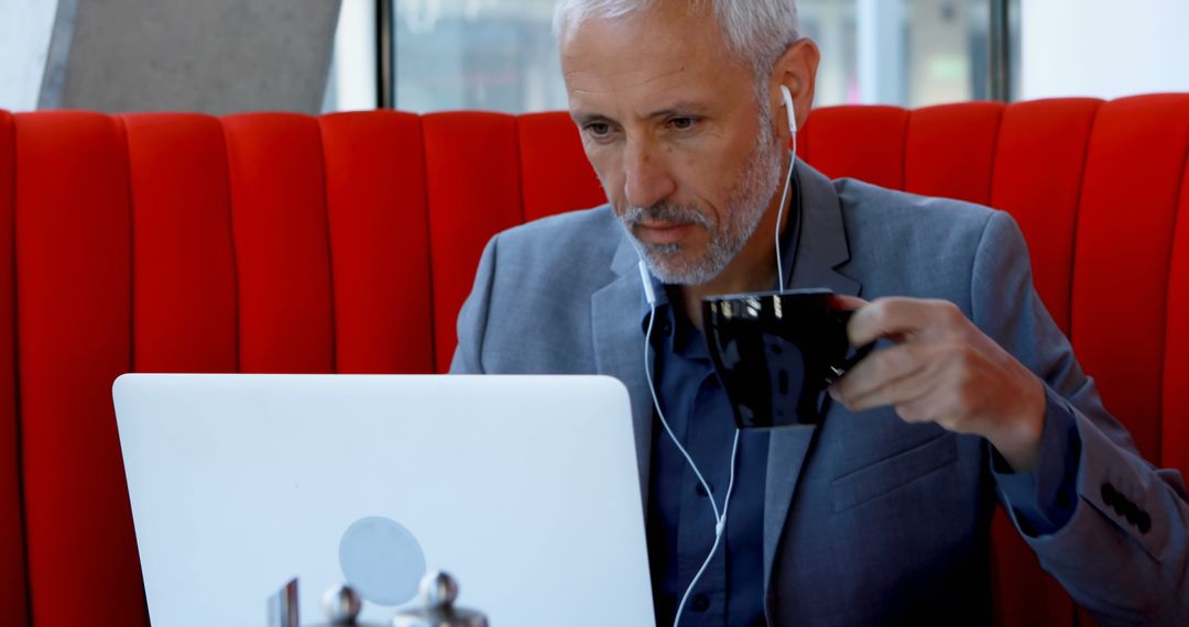 Focused Businessman with Laptop Working in Coffee Shop - Free Images, Stock Photos and Pictures on Pikwizard.com