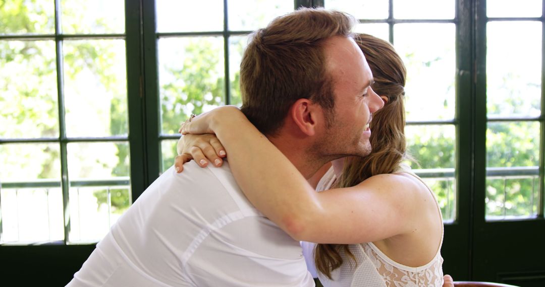 Happy Couple Embracing in Sunlit Room - Free Images, Stock Photos and Pictures on Pikwizard.com