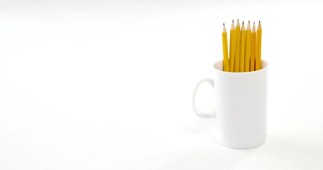 Yellow Pencils in White Mug on Minimalist White Background
