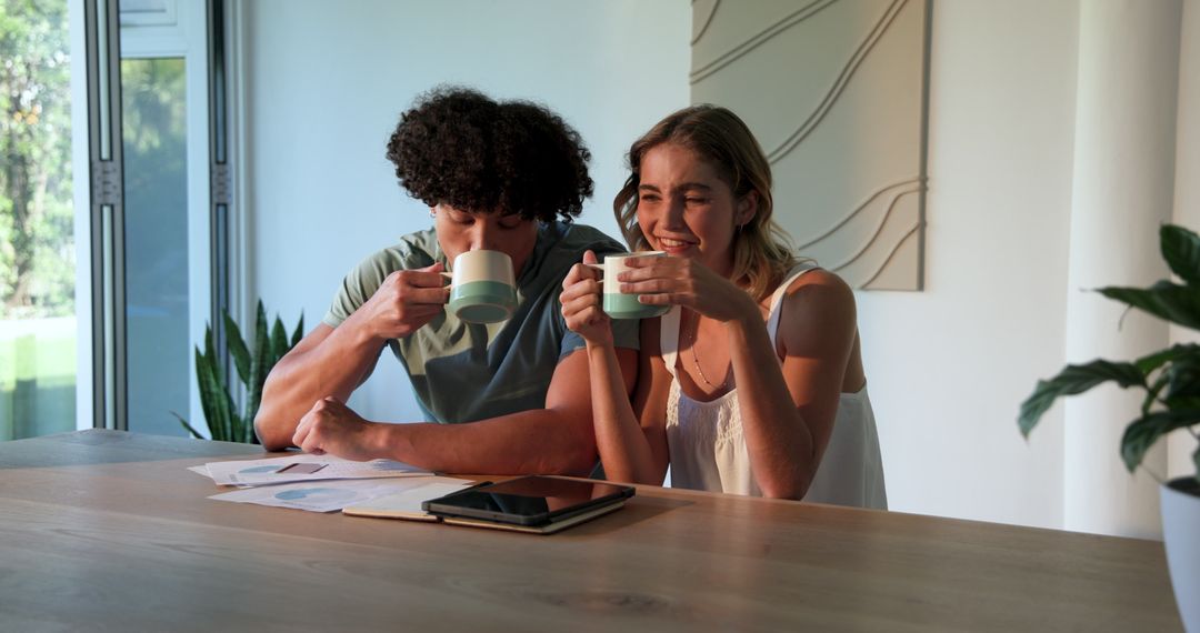 Happy Couple Reviewing Finances Together at Home with Tablet