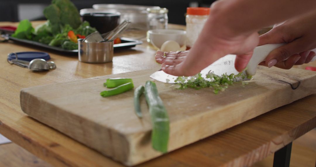 Close-Up of Hands Chopping Vegetables on Wooden Cutting Board in Kitchen - Free Images, Stock Photos and Pictures on Pikwizard.com