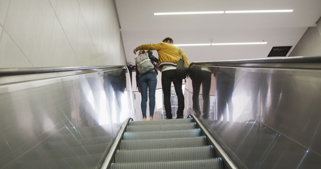 Couple Embracing While Riding Escalator in Modern Building - Free Images, Stock Photos and Pictures on Pikwizard.com