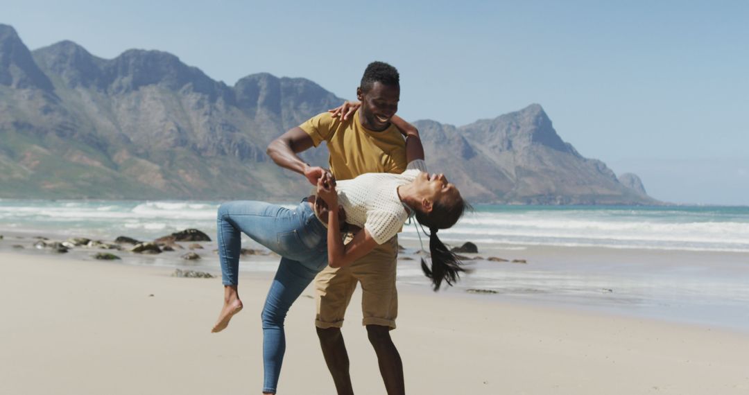 Romantic Couple Dancing on Scenic Beach against Mountain Background - Free Images, Stock Photos and Pictures on Pikwizard.com