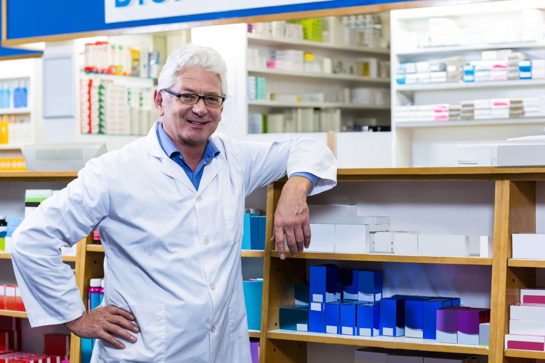 Elderly Pharmacist Organizing Medicine Boxes in Pharmacy