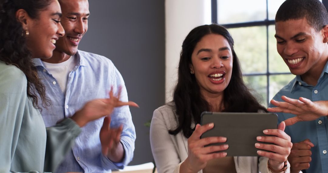 Diverse Team Celebrating Success with Tablet in Modern Office