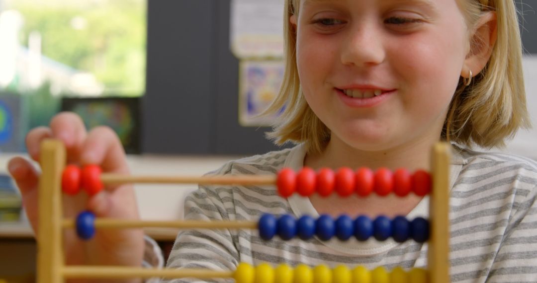Young Student Enjoys Counting with Abacus in Classroom