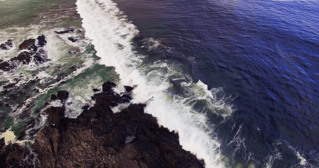 Transparent Blue Sea Waves Crashing on Rocky Coastline