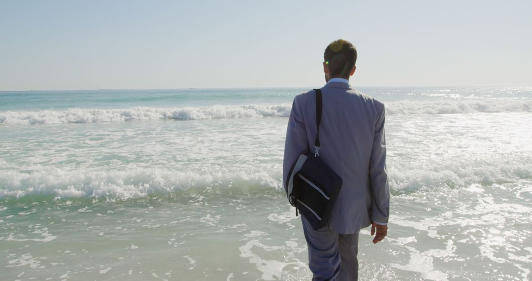 Businessman Walking Towards Ocean for a Refreshing Break - Free Images, Stock Photos and Pictures on Pikwizard.com
