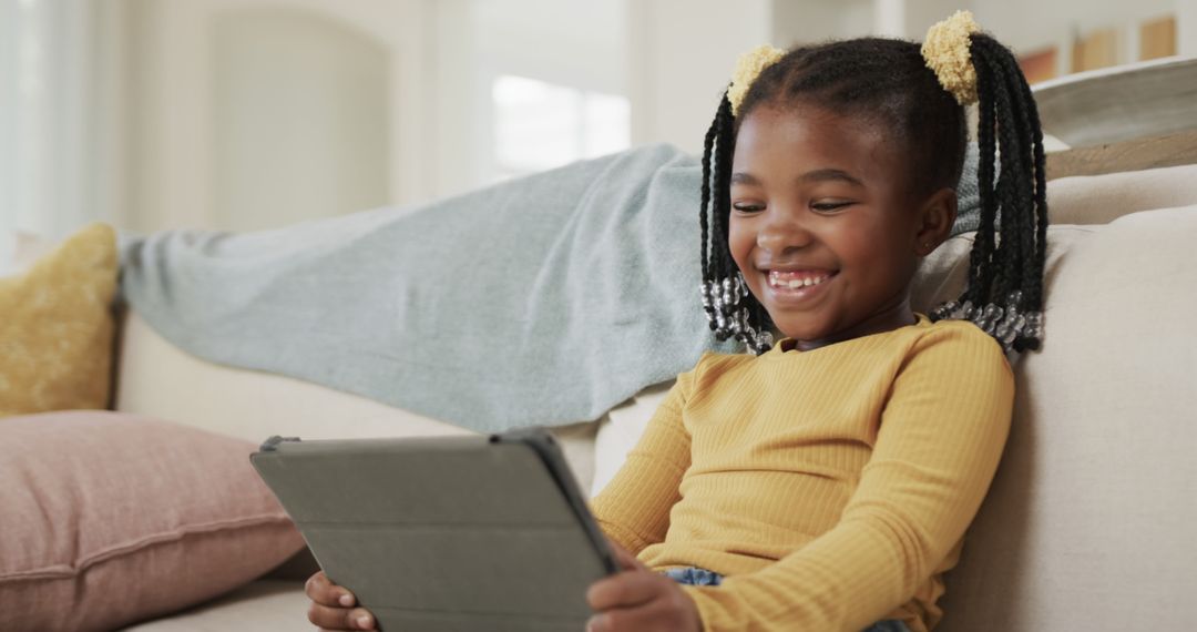 Happy African American Girl Using Tablet at Home - Free Images, Stock Photos and Pictures on Pikwizard.com