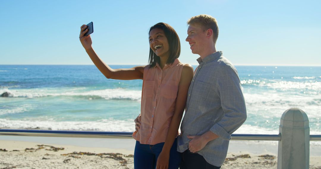 Mixed Race Couple Taking Selfie at Beach on Sunny Day - Free Images, Stock Photos and Pictures on Pikwizard.com